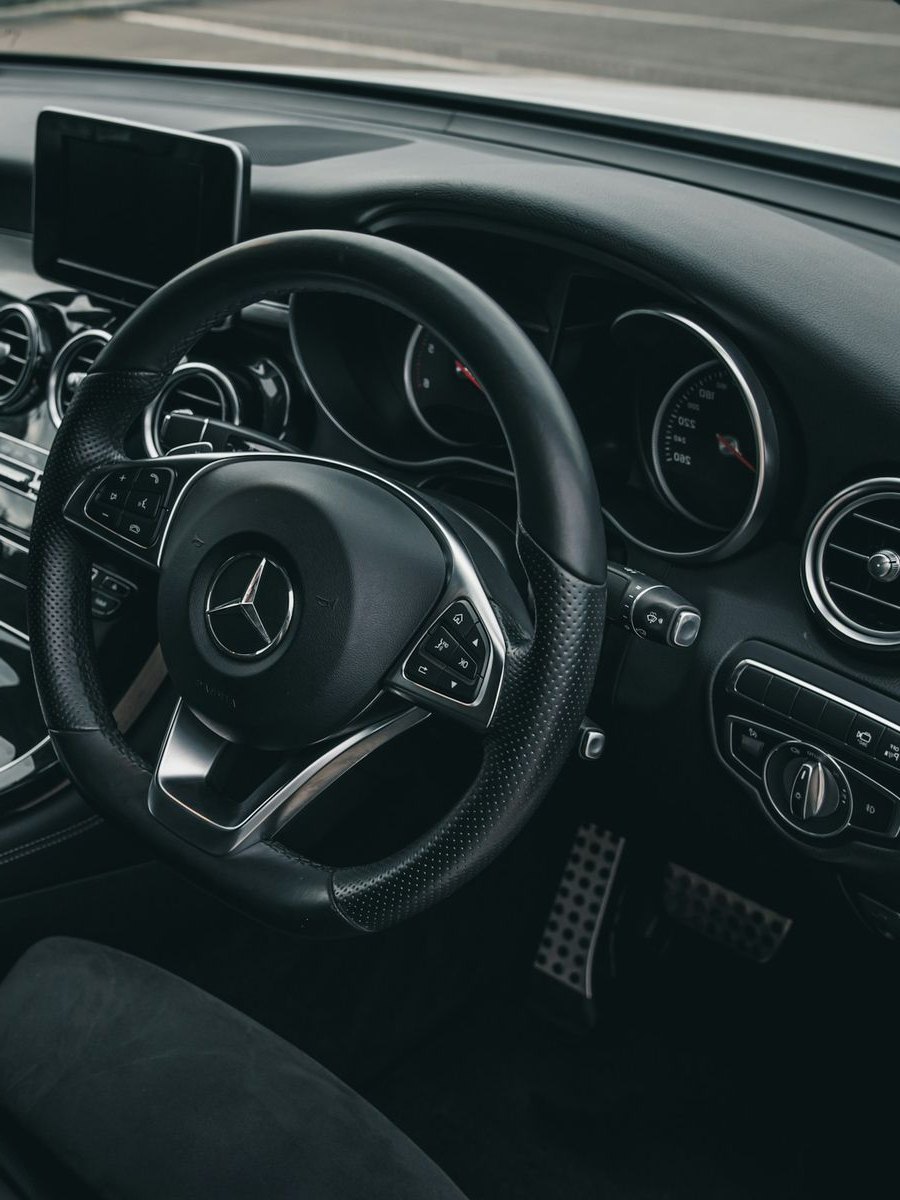 Driver's view of a Mercedes interior, with steering wheel and centre console